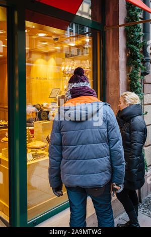 Straßburg, Frankreich - Dec 27, 2017: Rückansicht nach Paar am Schaufenster von Maison Alsacienne de Biscuiterie Bäckerei in Straßburg in der Rue de Dome suchen Stockfoto