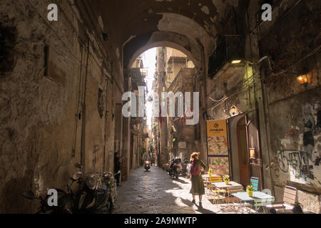 Sonne, die in einer schmalen Gasse im Stadtzentrum von Neapel durch die Gebäude kommt Stockfoto