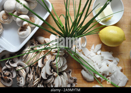 Schnittlauch von oben mit in Scheiben geschnittenen Champignons und Zwiebeln auf einem Holzbrett Stockfoto