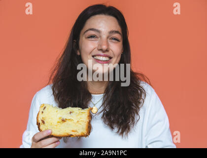 Junge Frau isst ein Stück Panettone Stockfoto