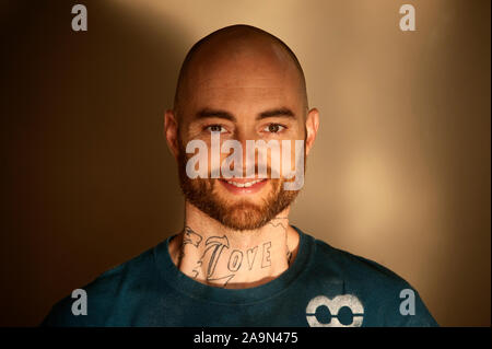 Im mittleren Alter Mann mit einem Hals Tattoo und Bart portrait. Stockfoto