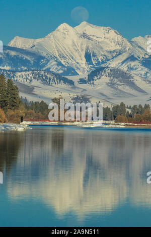 Mond über der flathead River und Mission Berge im Winter in der Nähe von Dixon, Montana Stockfoto