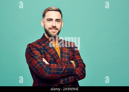 Taille bis Portrait von zuversichtlich, bärtiger Mann lächelnd an Kamera, während gegen mint grün Hintergrund posiert, Kopie Raum Stockfoto