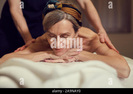 Portrait von eleganten Senior Frau genießen Massage im luxuriösen Spa Center, Kopie Raum Stockfoto