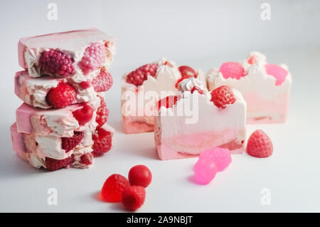 Handgemachte Seife rosa. Kalt verarbeitet Handgefertigte Seife. hausgemachte Seife aussehen wie Kuchen, Eis mit Beeren, Glitzer auf grauem Hintergrund mit funkelt Stockfoto