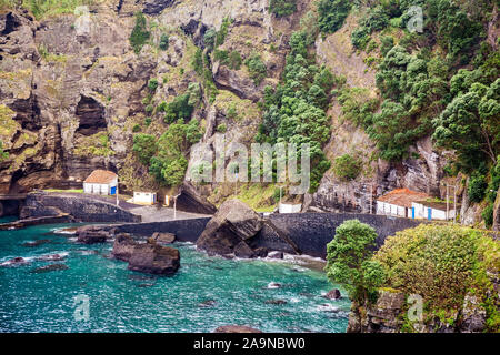 Kleine Bucht für Fischerboote auf dem Hintergrund der hohen Klippen auf Sao Miguel, Azoren, Portugal Stockfoto