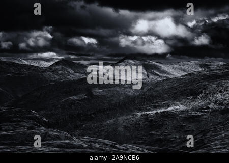 Uneinheitliche Sonnenlicht über malerische Berge im Herbst in Lake District National Park, Großbritannien - Monochrom bearbeiten Stockfoto