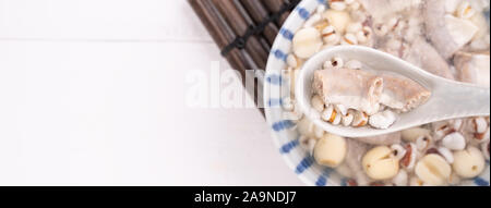 Lecker vier Stärkungsmittel Kraut Geschmack Suppe, Taiwanesische traditionelle Speisen mit Kräutern, schweinedickdarm auf weissem Holztisch, Nahaufnahme, Flach, Ansicht von oben. Stockfoto