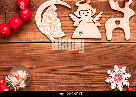 Weihnachten und neues Jahr dekorative Holz- handgefertigte Geschenk Spielzeug für Xmas Tree: Reh, Engel, Weihnachtsmann und Schneekugel mit roten kleinen künstlichen Äpfeln auf Stockfoto