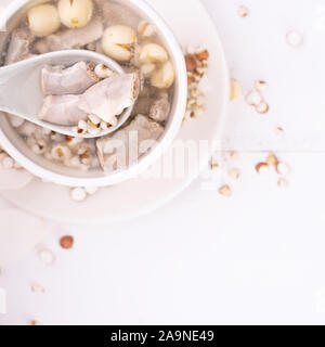 Lecker vier Stärkungsmittel Kraut Geschmack Suppe, Taiwanesische traditionelle Speisen mit Kräutern, schweinedickdarm auf weissem Holztisch, Nahaufnahme, Flach, Ansicht von oben. Stockfoto