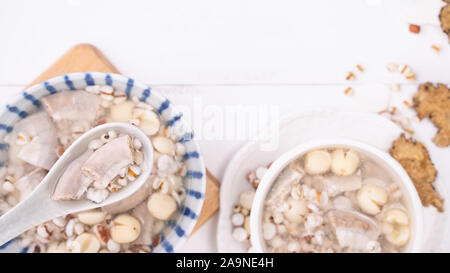 Lecker vier Stärkungsmittel Kraut Geschmack Suppe, Taiwanesische traditionelle Speisen mit Kräutern, schweinedickdarm auf weissem Holztisch, Nahaufnahme, Flach, Ansicht von oben. Stockfoto