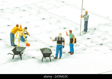 Miniatur Menschen Surveyor ist ein Techniker Messen der Entfernung ein Haus zu bauen. Stockfoto