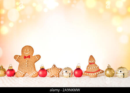 Weihnachten Komposition mit Gingerbread Man, Cookies und Ornamente auf hellen Hintergrund mit goldenen Bokeh leuchtet. Trendy Weihnachten Konzept, kopieren. Stockfoto