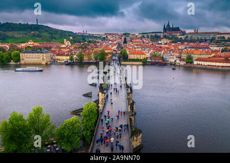 Schöne Stadtbild mit spektakulären Laufsteg auf der Karlsbrücke. Touristen mit bunte Sonnenschirme wandern in regnerischen Tag, Prag, Tschechische Republik, Eur Stockfoto