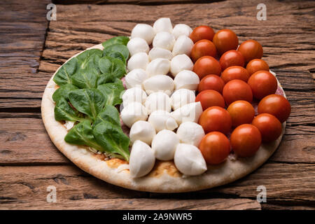 Mozzarella Käse und Gemüse Topping auf Pizza über Holz- Tabelle Stockfoto