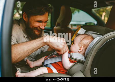 Vater, Baby in Sicherheit Autositz Vater und Kind zusammen mit der Familie im Auto Urlaub lifestyle Kleinkind Transport nach hinten Stockfoto