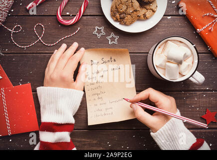 Mädchen schreiben möchten, Brief an Santa Claus auf hölzernen Tisch Stockfoto