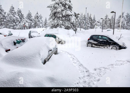 Autos auf dem Parkplatz im Schnee während eines Schneesturmes abgedeckt. Bild Stockfoto