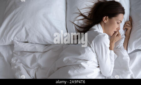 Erschrocken aufgewacht, einsame Frau im Bett allein liegen, Ansicht von oben Stockfoto