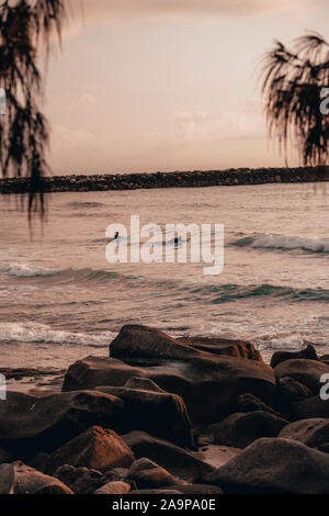 Zwei surfer Paddeln bei Sonnenaufgang am Turners Beach, Yamba New South Wales. Stockfoto