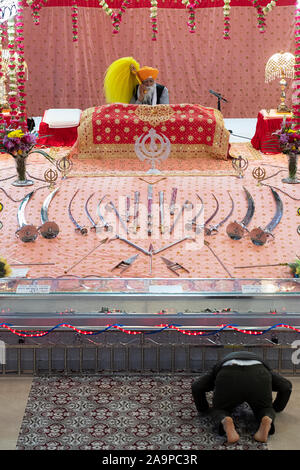 Der Altar in der Sikh kulturellen Gesellschaft Tempel in Richmond Hill, Queens, New York mit einem Verehrer kniend im Vordergrund. Stockfoto