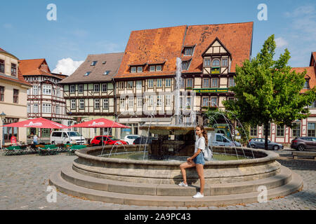 Junge touristische Mädchen vor einem Brunnen in der Altstadt von Quedlinburg, einem der Marktplätze in der mittelalterlichen Stadt. Stockfoto