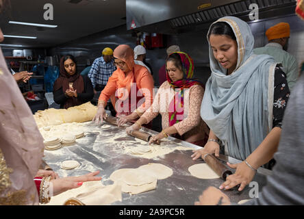Frauen aller Altersgruppen vorbereiten roti Brot in einem Langar, eine kostenlose Gemeinschaftsküche. In South Richmond Hill, Queens, New York City. Stockfoto