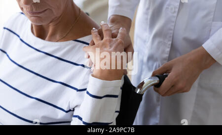 Weibliche Krankenschwester Pfleger Unterstützung älterer Oma zum Rollstuhl, Nahaufnahme Stockfoto