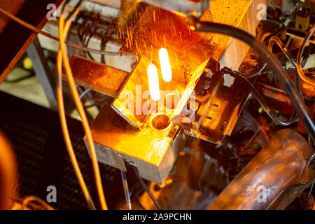 Glashütte. Glasindustrie. Brennen von Rohlingen aus Glas Flaschen in einem industriellen Herd Stockfoto