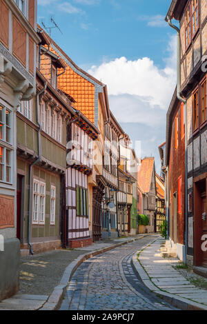 Blick auf eine schmale Straße mit traditionellen farbenfrohen Fachwerkhäuser in der alten mittelalterlichen Stadt Quedlinburg, Teil des UNESCO-Weltkulturerbe. Stockfoto