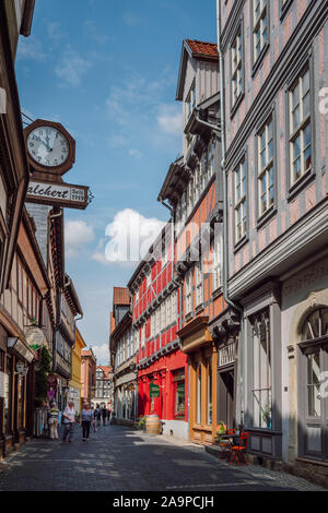 Blick auf eine Straße mit bunten Fachwerkhäusern und Touristen zu Fuß rund um die Altstadt in die UNESCO-Weltkulturerbestadt Quedlinburg. Stockfoto