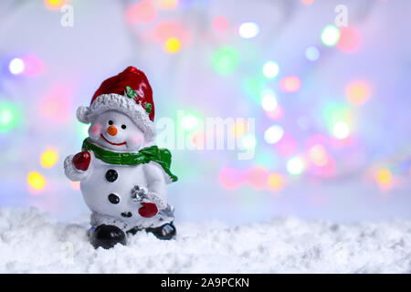 Schneemann im Schnee mit Bokeh verschwommenes Licht. Stockfoto