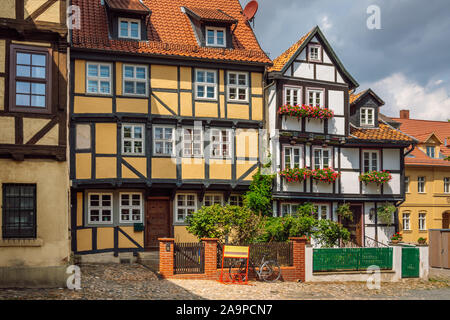 Bunte traditionelle Fachwerkhäuser mit Fenster geschmückt mit Blumen. Straße mit Rahmen Häuser in der Altstadt von Quedlinburg. Stockfoto
