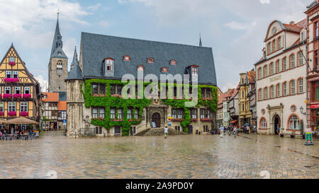 Blick auf den Marktplatz mit Touristen in Quedlinburg Altstadt, ein Café im Freien in einem traditionellen Fachwerkhaus und die Kirche "St. Benedikt" Stockfoto