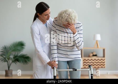 Junge Frau Physiotherapeut Betreuer trostreiche traurig verletzt alten Oma patient Stockfoto