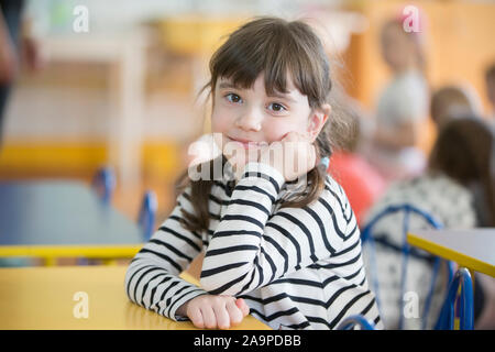 Belarus, die Stadt Gomel, 26. April 2019. Tag im Kindergarten zu öffnen. Girl Vorschüler. Porträt eines sechs Jahre alten Kind. Junior student an ihrem Schreibtisch. Stockfoto