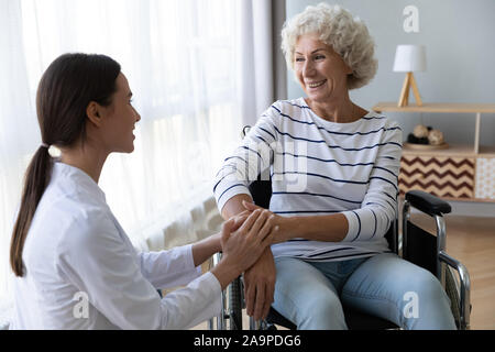 Fürsorgliche Frau Krankenschwester Unterstützung deaktiviert ältere Frau Patienten im Rollstuhl Stockfoto