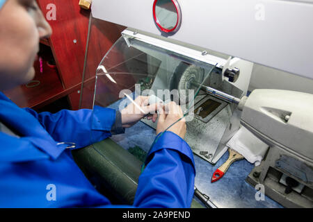 Belarus, die Stadt von Gomil, 24. April 2019. Schmuck Industrie. Eine Arbeiterin macht Gold Schmuck. Eine Frau Polituren einen Ring. Stockfoto