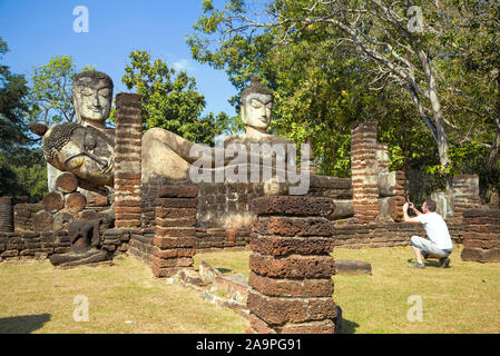 KAMPHENG PHET, THAILAND - 30. Dezember 2016: Europäische Touristen Fotos Buddha Skulpturen auf den Ruinen des buddhistischen Tempel Wat Phra Kaeo Stockfoto