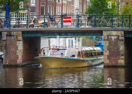AMSTERDAM, NIEDERLANDE, 30. SEPTEMBER 2017: Touristen Sightseeing Boat Pass unter der Stadt Brücke auf einen Herbst Tag Stockfoto