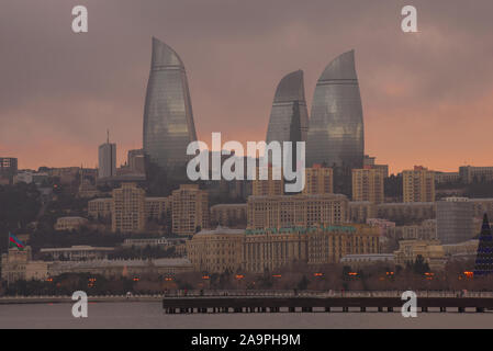 BAKU, Aserbaidschan - Januar 04, 2018: Flamme Türme in einer Stadt Landschaft vor dem Hintergrund einer bewölkt Januar Sonnenuntergang Stockfoto