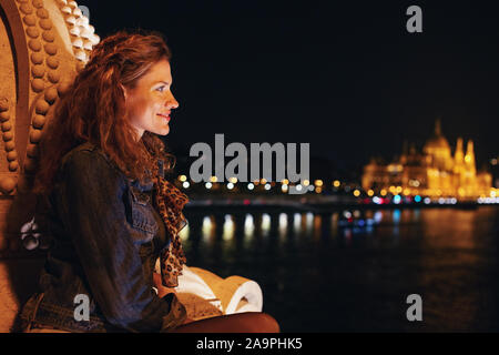 Glückliche junge rothaarige Frau, die mich Nacht Panorama in Budapest, Ungarn Stockfoto