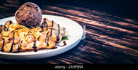 Leckere Pfannkuchen mit Schokolade Eis knusprige Waffeln mit Schlagsahne brownies cherry Mandeln und Schokolade Sirup auf die Oberseite mit Mais-flex. Sommer hol Stockfoto