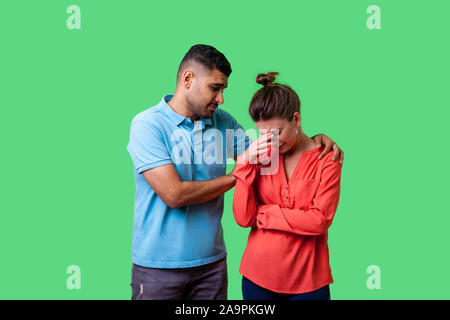 Portrait von unglücklichen besorgt junges Paar in Freizeitkleidung, Mann tröstet weinende Frau, halten Sie Ihre Schultern, drückt Mitgefühl. Stockfoto