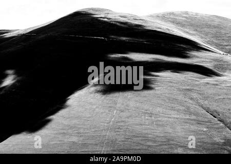 Schwarze Schatten der Wolken, die über einem Hügel Stockfoto