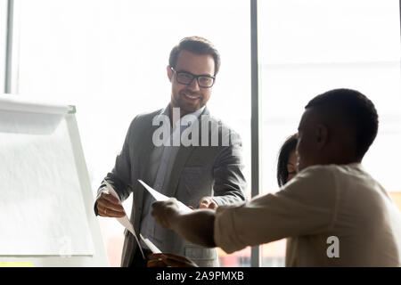 Lächelnd afrikanische amerikanische Mitarbeiter geben Papier Bericht zu trainieren. Stockfoto