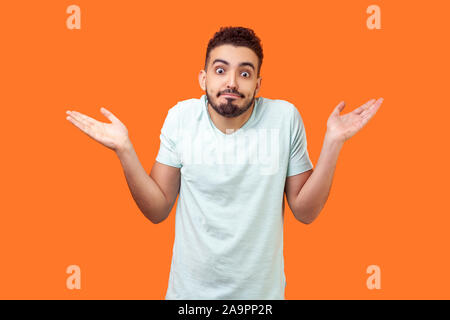 Ich weiß nicht, wer sich interessiert. Portrait von verwirrt clueless brünett Mann mit Bart im weißen T-Shirt zuckte mit den Schultern, so dass keine Idee, Geste, was auch immer. Stockfoto