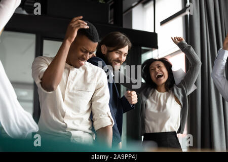 Happy crazy multirassischen jüngere und ältere Mitarbeiter, die Spaß haben. Stockfoto