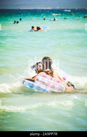 Alcudia, Spanien 13.09.2011 - Paar schwimmen auf aufblasbaren Matratze im seichten Wasser an der Playa de Muro. Mallorca Insel berühmten touristischen Ziel. Stockfoto