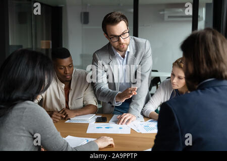 Selbstbewussten jungen Mitarbeiter Ideen mit fokussierten Gruppe konzentriert. Stockfoto